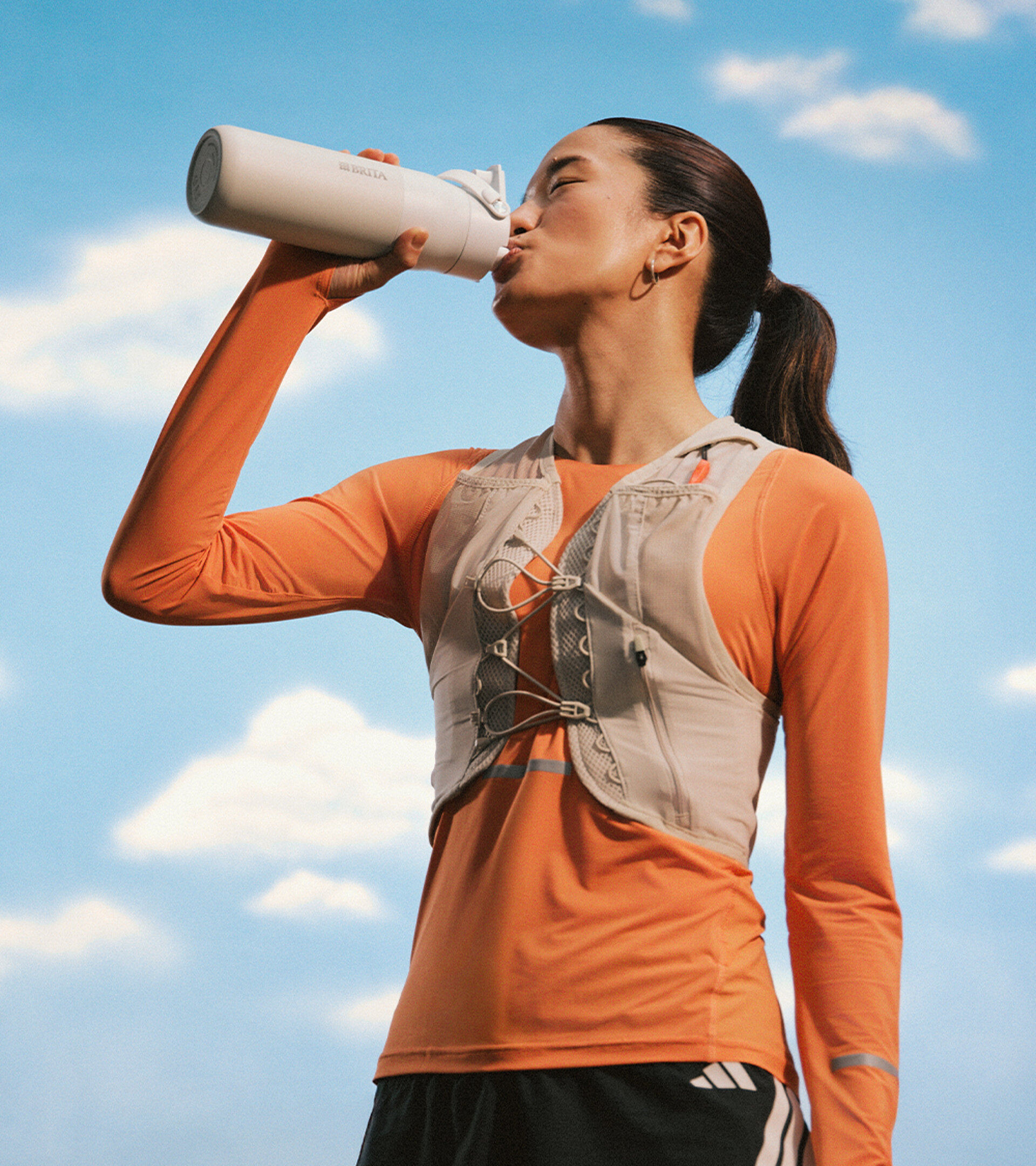 Sportlerin trinkt genüsslich aus ihrer Sportflasche.