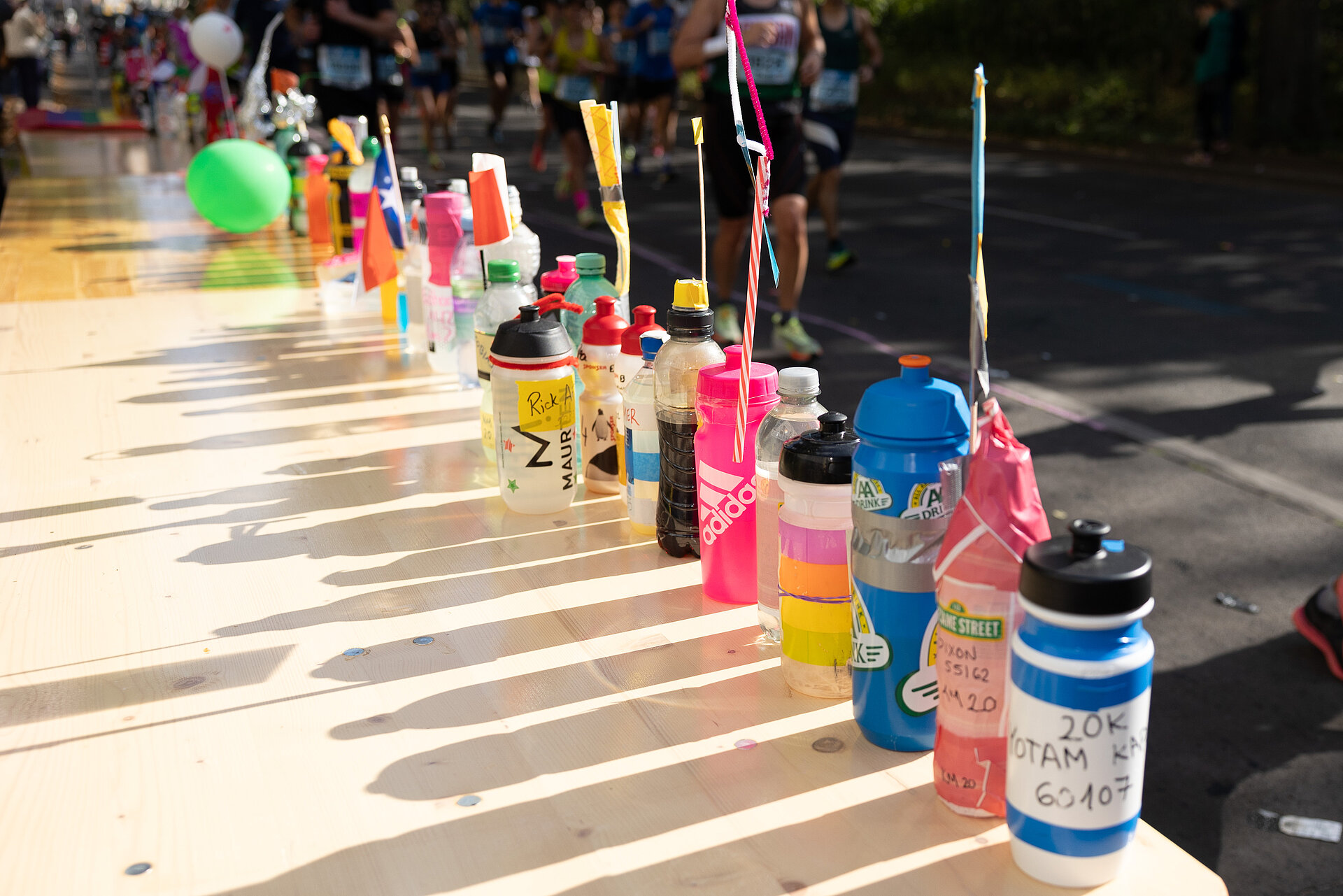 BMW BERLIN-MARATHON course: Next to the participants - wooden table with personal drinking bottles for self-catering during the race © SCC EVENTS / Norbert Wilhelmi