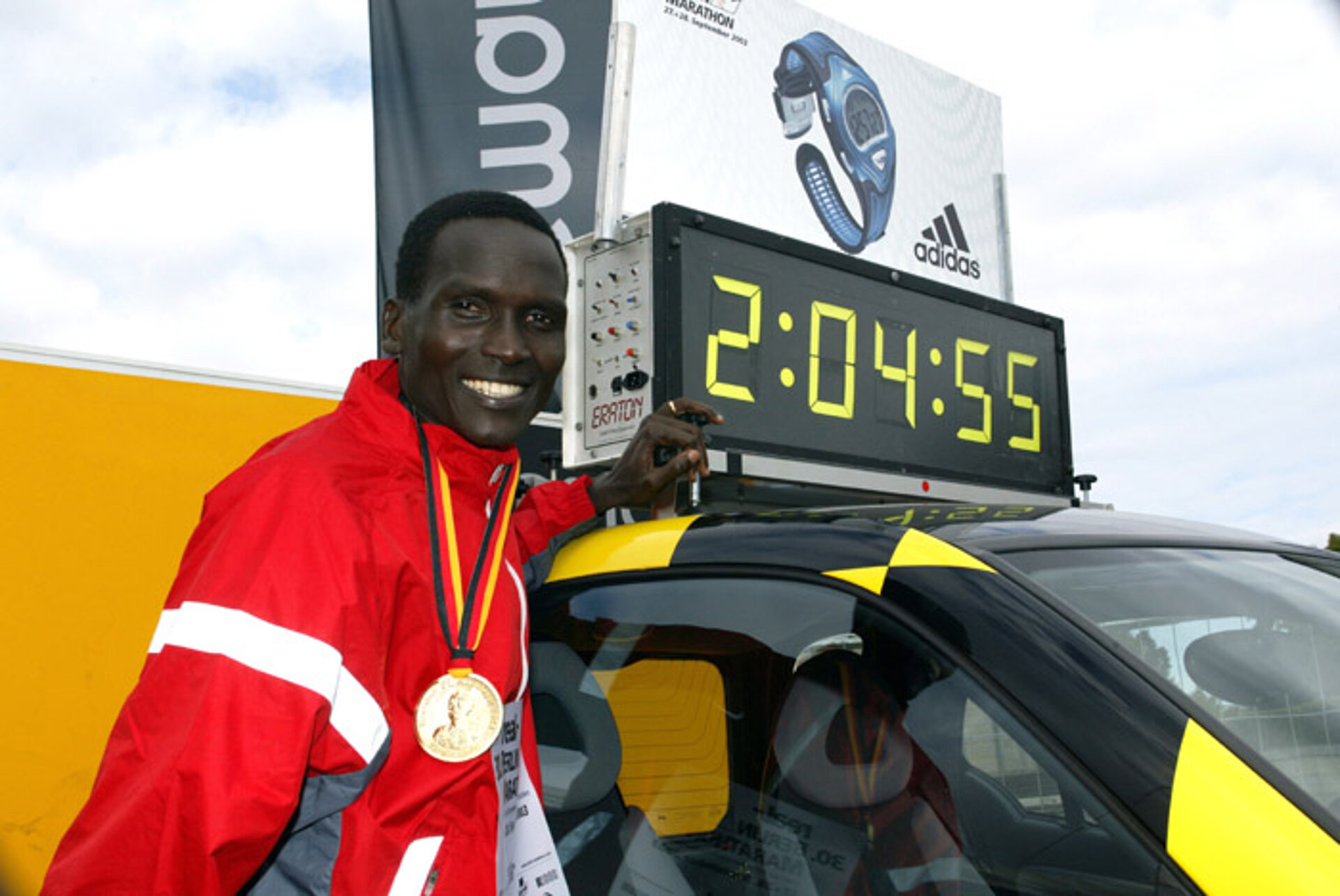 Paul Tergat vor einer Uhr mit seiner Laufzeit © SCC Events