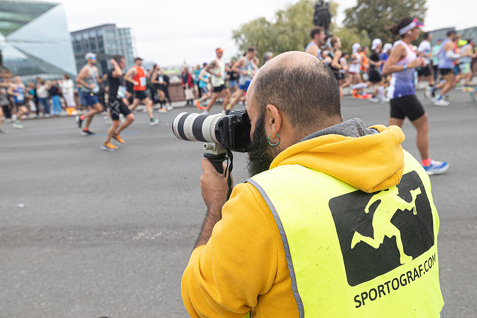 BMW Berlin Marathon: Fotograf von den Sportografen nimmt Läufer vor dem Cube Berlin auf © SCC EVENTS / Norbert Wilhelmi