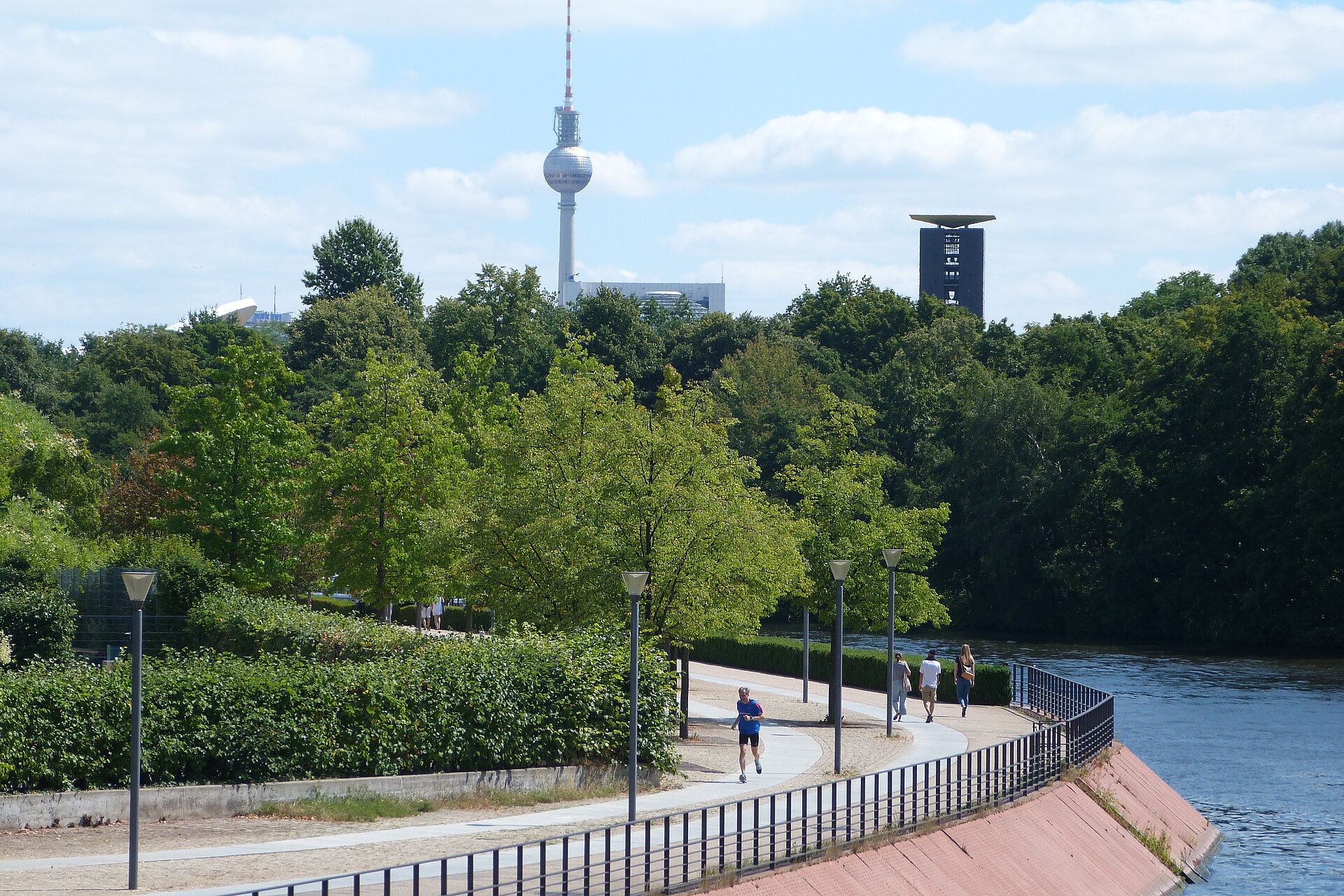 BMW BERLIN-MARATHON: Läufer und Spaziergänger am Spreeufer, der Fernsehturm im Hintergrund © SCC Events