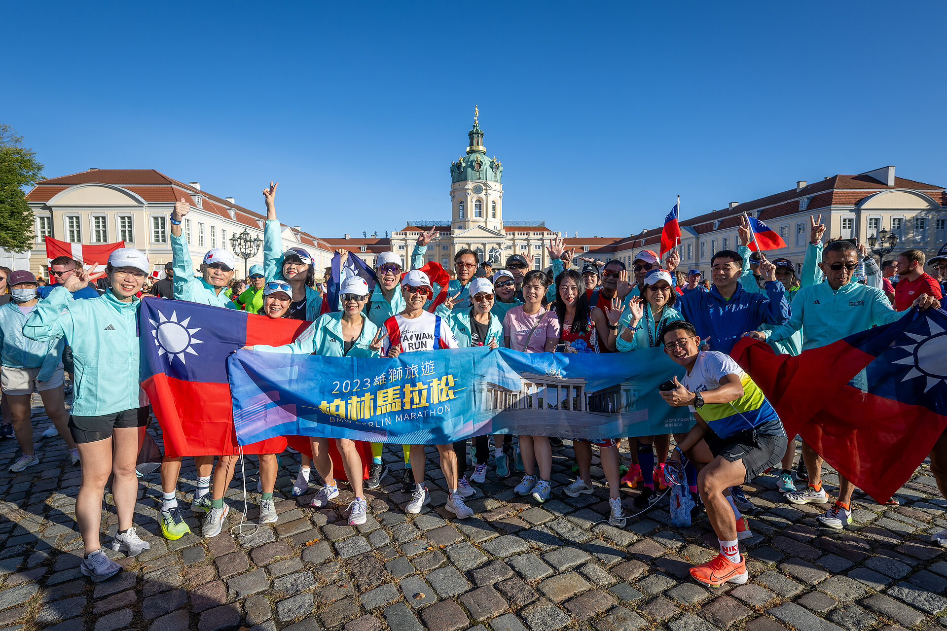 BMW BERLIN-MARATHON Registrierung: Teilnehmer des Taiwan Excellence Team posiert vorm Schloss Charlottenburg © SCC EVENTS/ Tilo Wiedensohler