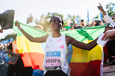 BMW Berlin Marathon 2023: Siegerin Tigst Assefa mit äthiopischer Flagge