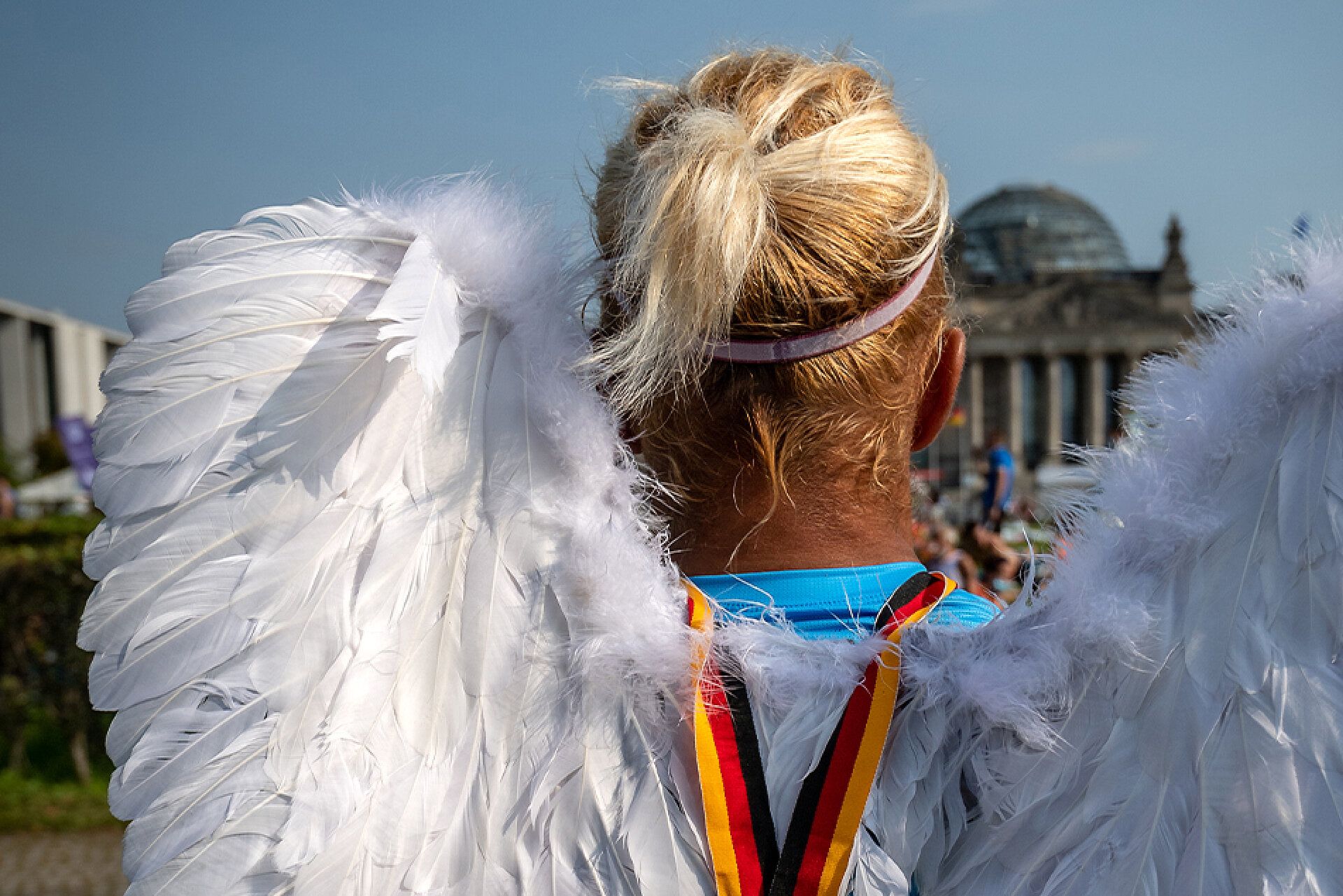 BMW BERLIN-MARATHON: Läufer:in mit Engelsflügeln schaut auf den Berliner Reichstag © SCC EVENTS / camera4