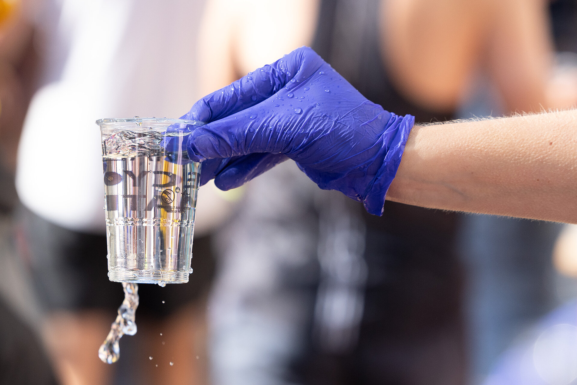 BMW BERLIN-MARATHON Strecke: Volunteer reicht Plastikbecker mit Wasser zur Verpflegung der Laufenden © SCC EVENTS / Norbert Wilhelmi