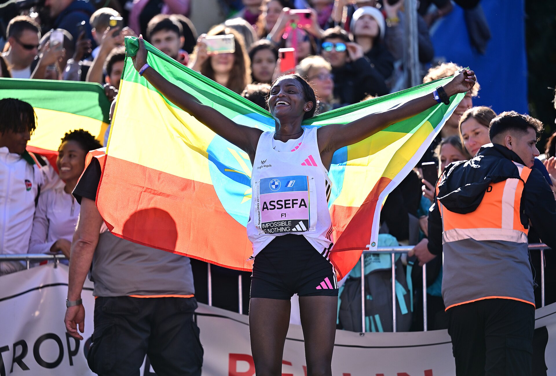 BMW BERLIN-MARATHON: Siegerin von 2023 Tigst Assefa mit der Flagge Äthiopiens © SCC EVENTS / Petko Beier