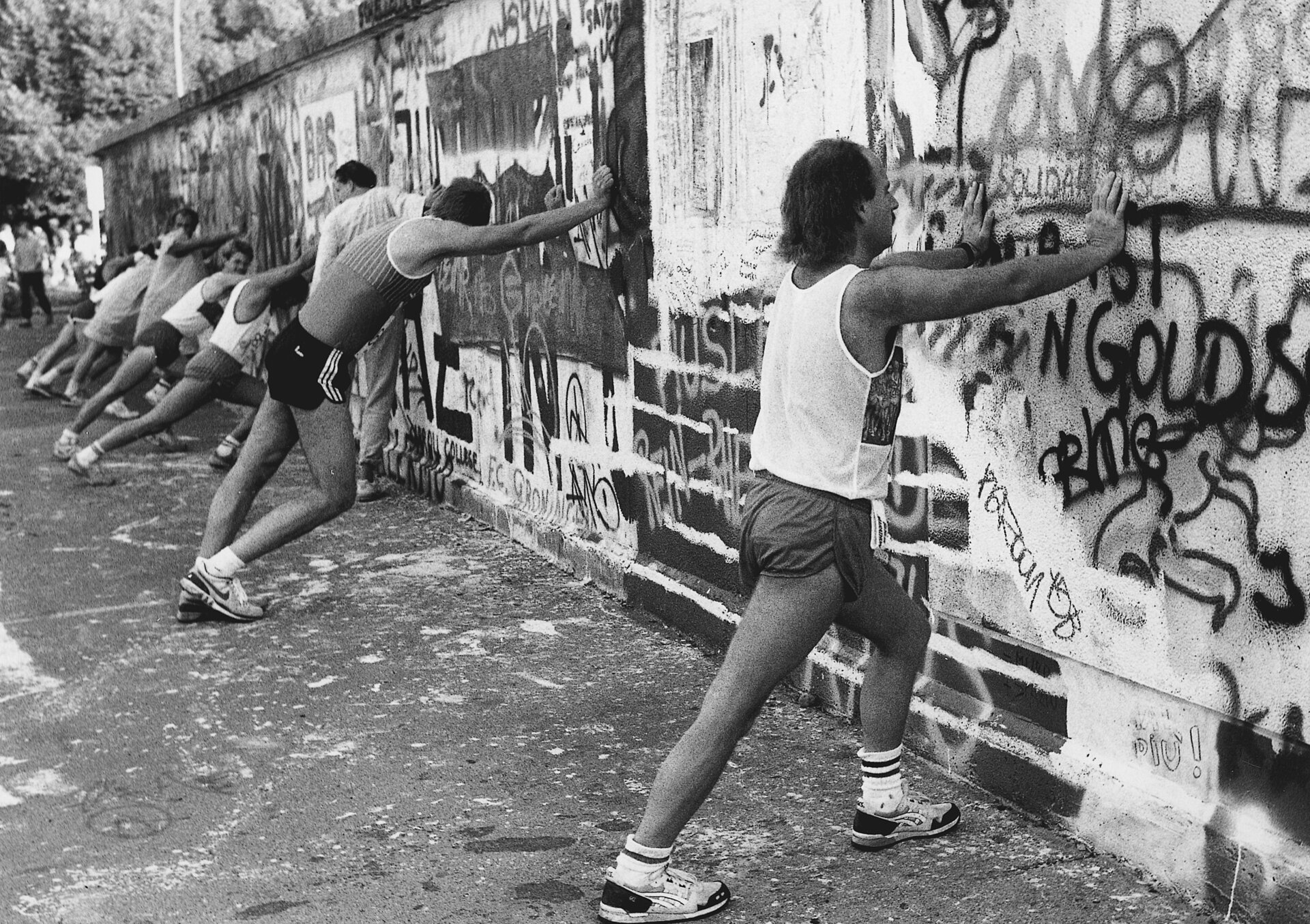 BMW BERLIN-MARATHON: Participants stretch at the Berlin Wall © SCC EVENTS