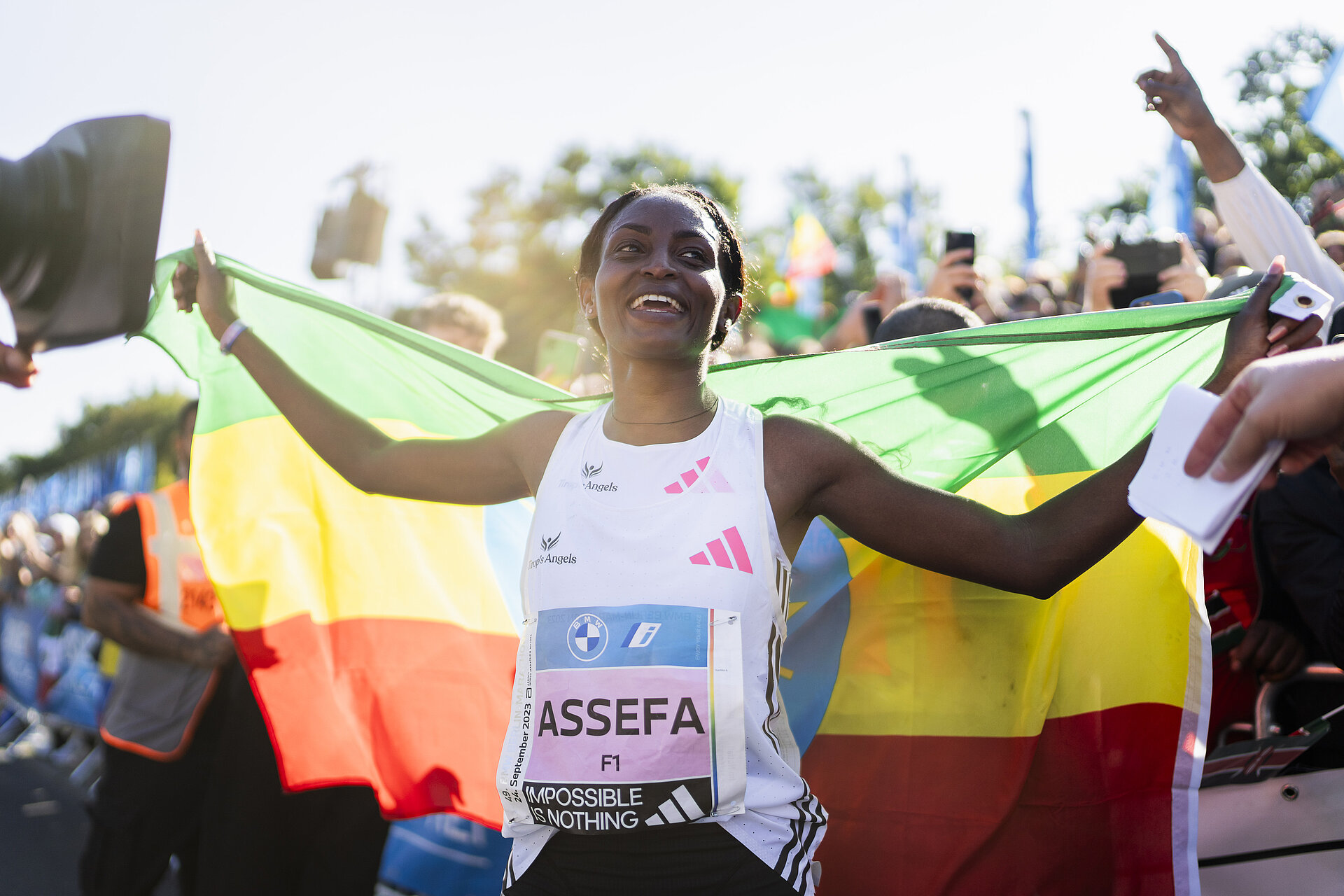 BMW BERLIN-MARATHON 2023: Siegerin Tigist Assefa mit äthiopischer Flagge © SCC EVENTS